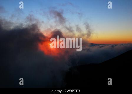 Coucher de soleil sur le Mauna Kea au-dessus des nuages, Big Island, Hawaii Banque D'Images