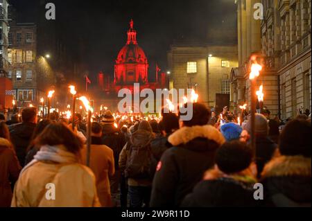 Édimbourg, Écosse, Royaume-Uni. 29 décembre 2023. Quatre jours de célébrations de Hogmanay débutent avec les Vikings du South Mainland des Shetland jusqu'à Helly AA' Jarl Squad menant la procession des flambeaux de Hogmanay de 20 000 personnes à travers la vieille ville historique de la capitale. Procession sur le pont George IV avec le dôme de la Bank of Scotland illuminé en rouge. Crédit : Craig Brown/Alamy Live News Banque D'Images