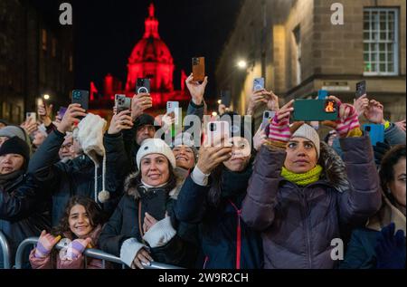 Les spectateurs assistent à la procession aux flambeaux dans le centre-ville d'Édimbourg, menée par les Vikings de la Shetland South Mainland Up Helly AA Jarl Squad, dans le cadre de l'événement inaugural des célébrations du Hogmanay à Édimbourg. Date de la photo : Vendredi 29 décembre 2023. Banque D'Images