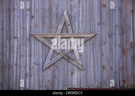 Texture de mur d'une ancienne grange battue par temps avec une étoile en bois Banque D'Images