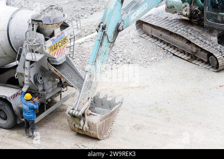 Les tuyaux sont arrosés avec des camions de ciment et des camions excavateurs Banque D'Images