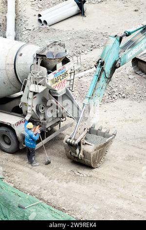Les tuyaux sont arrosés avec des camions de ciment et des camions excavateurs Banque D'Images