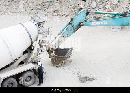 Les tuyaux sont arrosés avec des camions de ciment et des camions excavateurs Banque D'Images