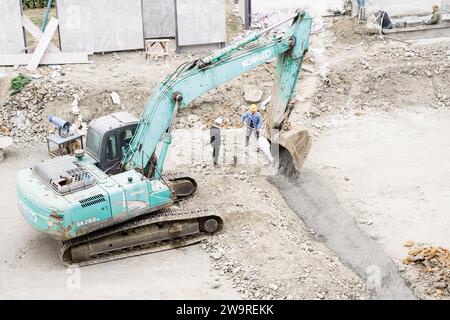 Les tuyaux sont arrosés avec des camions de ciment et des camions excavateurs Banque D'Images