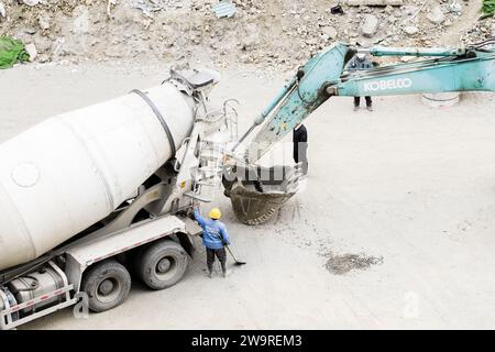 Les tuyaux sont arrosés avec des camions de ciment et des camions excavateurs Banque D'Images