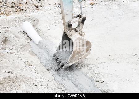 Les tuyaux sont arrosés avec des camions de ciment et des camions excavateurs Banque D'Images