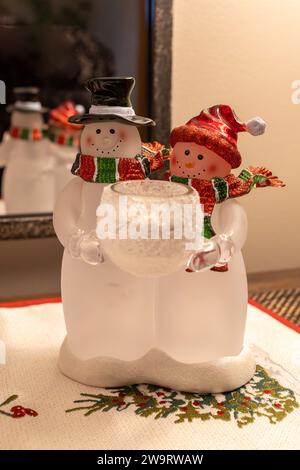 Ornement coloré de dessus de table de Noël représentant un homme de neige et une femme tenant une bougie Banque D'Images