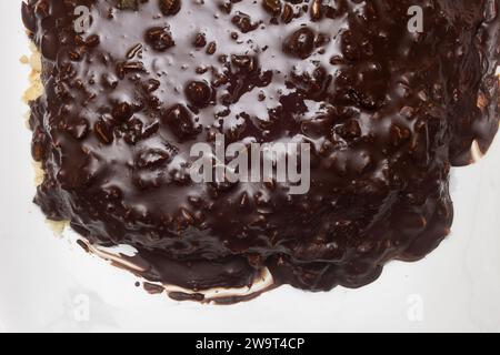 Vue aérienne de la couche supérieure de chocolat noir avec des amandes sur le bord d'un plateau en céramique blanche avec espace de copie. Banque D'Images