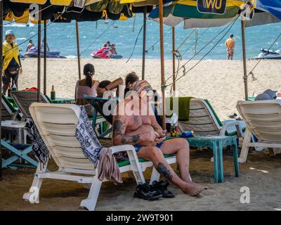 Pattaya, Thaïlande. 27 décembre 2023. Un vieil homme est assis seul sur la plage de Pattaya. Pattaya Beach est une destination touristique bien connue en Thaïlande. Mais alors que la ville de Pattaya a acquis une réputation pour sa vie nocturne animée et ses options de divertissement, elle ne se concentre pas uniquement sur la restauration pour les voyageurs solo masculins. Au-delà de sa vie nocturne, la ville attire divers touristes, y compris les familles, les couples et les individus de tous âges, pour le shopping, les activités nautiques et la détente en bord de mer. (Photo Nathalie Jamois/SOPA Images/Sipa USA) crédit : SIPA USA/Alamy Live News Banque D'Images