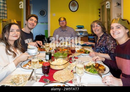 Famille ayant un dîner de Noël traditionnel autour d'une table en décembre 2023, Angleterre, Royaume-Uni Banque D'Images
