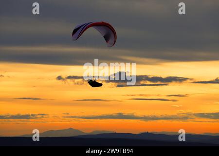 Silhouette de parapente contre le coucher du soleil. Parapente sur la colline de Pálava en République tchèque. Banque D'Images