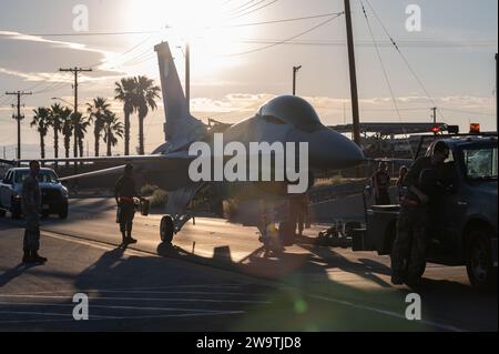 Des aviateurs américains du 57th Aircraft Maintenance Squadron transportent un F-16 Fighting Falcon à la base aérienne de Nellis le 21 juin 2023. Photo de Jordan McCoy Banque D'Images