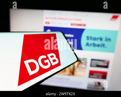 Téléphone portable avec logo de l'organisation allemande Deutscher Gewerkschaftsbund (DGB) devant le site Web. Effectuez le focus sur la gauche de l'écran du téléphone. Banque D'Images