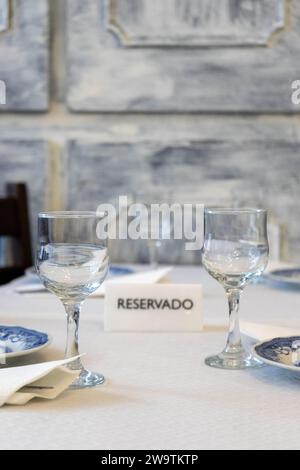 Panneau réservé au milieu de verres et assiettes sur une table dans un restaurant traditionnel. Banque D'Images