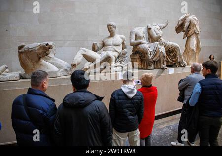 Londres, Royaume-Uni. 30 décembre 2023. Les visiteurs du British Museum voient des sculptures anciennes dans les galeries du Parthénon. Ils sont également appelés les marbres d'Elgin après que Lord Elgin les ait emmenés à Londres entre 1801 et 1812. Tony Blair a envisagé de les prêter à la Grèce comme une idée pour stimuler la candidature de Londres pour les Jeux olympiques de 2012. Une idée proposée est que la Grèce pourrait organiser des expositions tournantes de certains de ses objets les plus importants pour remplacer les marbres du Parthénon, si ceux-ci devaient être retournés à Athènes, a déclaré le ministre grec de la Culture. Crédit : Mark Thomas/Alamy Live News Banque D'Images