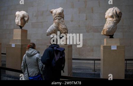 Londres, Royaume-Uni. 30 décembre 2023. Les visiteurs du British Museum voient des sculptures anciennes dans les galeries du Parthénon. Ils sont également appelés les marbres d'Elgin après que Lord Elgin les ait emmenés à Londres entre 1801 et 1812. Tony Blair a envisagé de les prêter à la Grèce comme une idée pour stimuler la candidature de Londres pour les Jeux olympiques de 2012. Une idée proposée est que la Grèce pourrait organiser des expositions tournantes de certains de ses objets les plus importants pour remplacer les marbres du Parthénon, si ceux-ci devaient être retournés à Athènes, a déclaré le ministre grec de la Culture. Crédit : Mark Thomas/Alamy Live News Banque D'Images