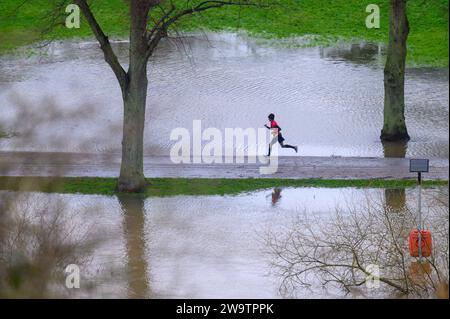 Runner longe la rivière Severn, qui a éclaté sur ses rives et inondé une partie du Quarry Park à Shrewsbury, Shropshire. Banque D'Images