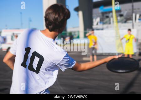 Processus de lancer Frisbee, enfants adolescents lancer disc golf à l'extérieur dans un parc de la ville dans une journée ensoleillée d'été, Frisbee jouant avec la famille, les enfants et Banque D'Images