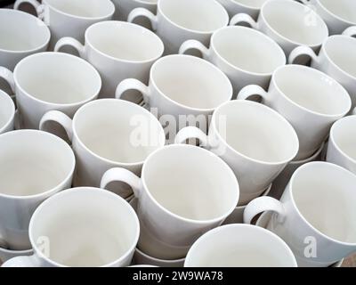 Les tasses blanches en céramique vides se tiennent en rangées Banque D'Images