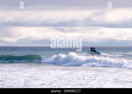 Un bateau de sauveteur patrouille la côte sud de la Californie pendant les conditions de surf à la plage de point Dume à Malibu, Californie, États-Unis Banque D'Images