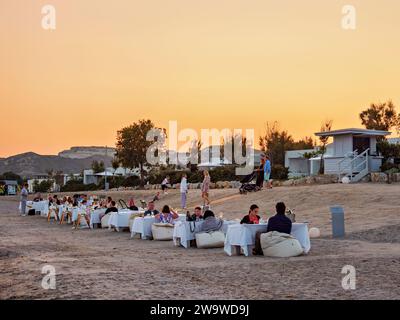 Les gens mangent al fresco à Agios Stefanos Beach, crépuscule, île de Kos, Dodécanèse, Grèce Banque D'Images