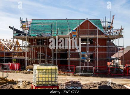 Nouvelle maison en cours de construction sur un lotissement avec des échafaudages autour Banque D'Images