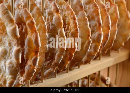 Pain plat croquant typique du Tyrol du Sud, appelé schuettelbrot, avec étagère en bois Banque D'Images