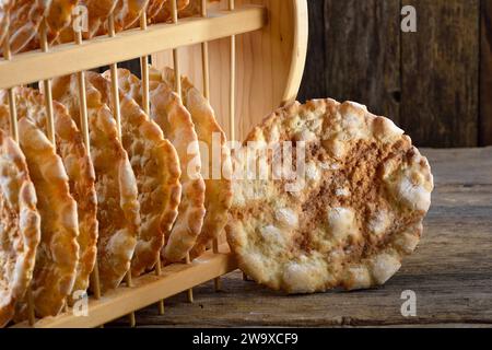 Pain plat croquant typique du Tyrol du Sud, appelé schuettelbrot, avec étagère en bois Banque D'Images