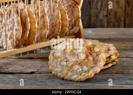 Pain plat croquant typique du Tyrol du Sud, appelé schuettelbrot, avec étagère en bois Banque D'Images