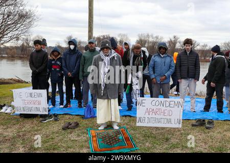 Harrisburg, États-Unis. 30 décembre 2023. Les hommes se préparent à prier lors d’un rassemblement pro-palestinien à Harrisburg Pa. Le 30 décembre 2023. Les manifestants ont placé plus de 20 000 drapeaux, un pour chaque personne tuée à Gaza depuis le début de la guerre israélo-Hamas, le long de la rue près de la résidence du gouverneur de Pennsylvanie. (Photo de Paul Weaver/Sipa USA) crédit : SIPA USA/Alamy Live News Banque D'Images