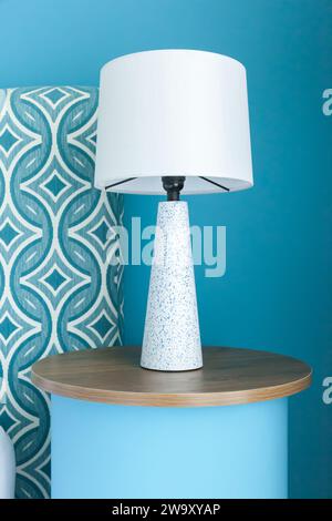 Lampe moderne sur une table en bois près du mur bleu de l'océan avec vue de face Banque D'Images