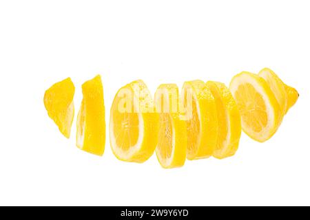 Zitrone in Scheiben geschnitten und frei schwebend vor weißem hintergrund. Un citron coupé en tranches et placé en rangée devant un fond blanc Banque D'Images