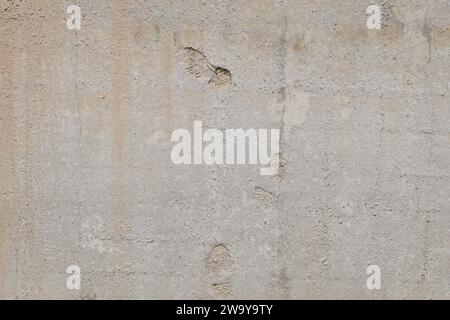 mur en béton massif gris plat avec empreintes de semelles de chaussures, fond plein cadre et texture Banque D'Images