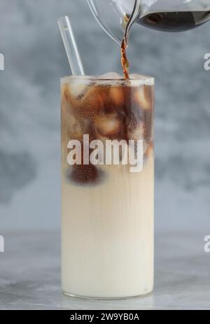 Versez l'espresso de café noir sur le lait, en faisant Iced Cafe Latte Banque D'Images