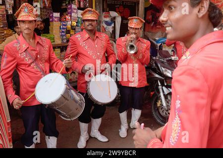 Une bande indienne de mariage et de festival, avec des batteurs en uniforme rouge et un trompettiste, lors d'un festival de rue à Mumbai, en Inde Banque D'Images