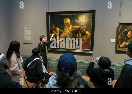 Groupe japonais visionnant le Belshazzar's Feast de Rembrandt, National Gallery, Londres, Royaume-Uni Banque D'Images