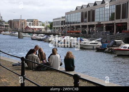 Bristol, Somerset, Royaume-Uni 06 16 2018 jeunes s'assoient ensemble au Harbourside à Bristol, Royaume-Uni Banque D'Images