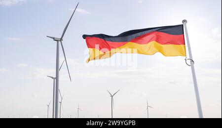Le drapeau allemand flotte sur le backgorund des éoliennes symbole du développement durable République fédérale d'Allemagne.. Banque D'Images