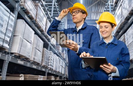 Équipe de gestionnaires d'entrepôt avec tablettes numériques. Banque D'Images