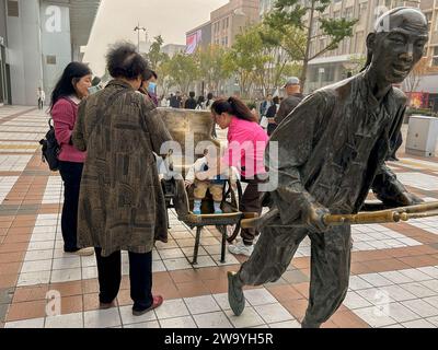 Pékin, Chine, scène de rue, petite foule de personnes, familles, avec enfant et sculpture moderne, rue commerçante, Wangfujing réunis, Centre ville, art 20ème Banque D'Images