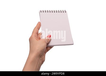 Un carnet avec du papier blanc vide dans les mains de femme avec des ongles rouges. Copier l'espace. Banque D'Images