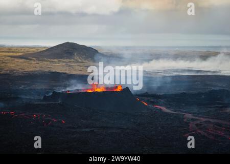 Vue spectaculaire d'un volcan en éruption, magma rouge bouillant dans un cratère faisant une température extrêmement chaude, vue latérale aérienne. Nature et catastrophe naturelle Banque D'Images