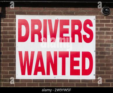 Décembre 2023, signe à l'extérieur du bureau d'une compagnie de taxi, Drivers Wanted, Angleterre, Royaume-Uni Banque D'Images