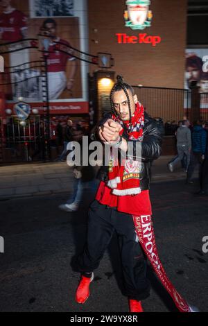 Jeune supporter de Liverpool FC portant une veste en cuir avec une écharpe Liverpool FC devant le Kop, stade de football à Anfield, Liverpool , Royaume-Uni . Banque D'Images