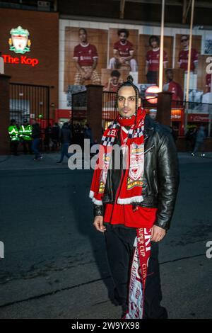 Jeune supporter de Liverpool FC portant une veste en cuir avec une écharpe Liverpool FC devant le Kop, stade de football à Anfield, Liverpool , Royaume-Uni. Banque D'Images