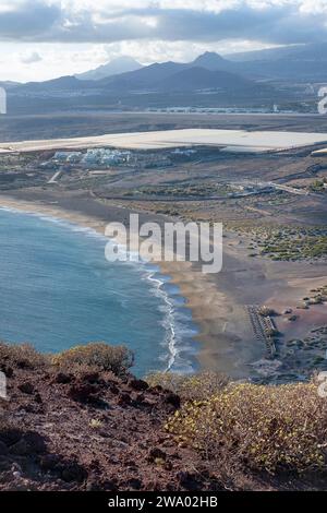 Vues surélevées depuis le pic volcanique Montana Roja vers la plage naturelle Playa de la Tejita et la station balnéaire voisine entourée de fermes et de plantations Banque D'Images