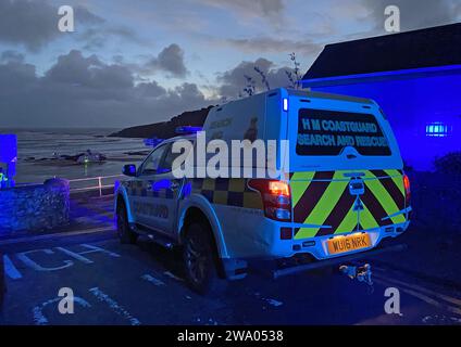 Swansea, Royaume-Uni. 31 décembre 2023. Un hélicoptère de la Garde côtière atterrit à Langland Bay sur la péninsule de Gower près de Swansea cet après-midi pour assister à une victime pendant les conditions orageuses alors que la dernière lumière de 2023 s’estompe dans la nuit. Crédit : Phil Rees/Alamy Live News Banque D'Images