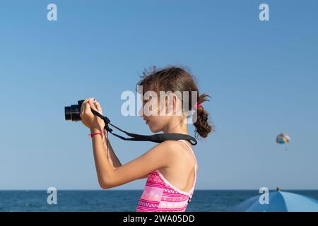 Adorable petite fille prenant la photo par appareil photo numérique Banque D'Images