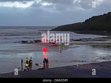 Swansea, Royaume-Uni. 31 décembre 2023. Hélicoptère de la Garde côtière atterrissant à Langland Bay sur la péninsule de Gower près de Swansea cet après-midi pour assister à une victime qui a été sauvée de la mer pendant les conditions orageuses alors que la dernière lumière de 2023 s'estompe dans la nuit. Crédit : Phil Rees/Alamy Live News Banque D'Images