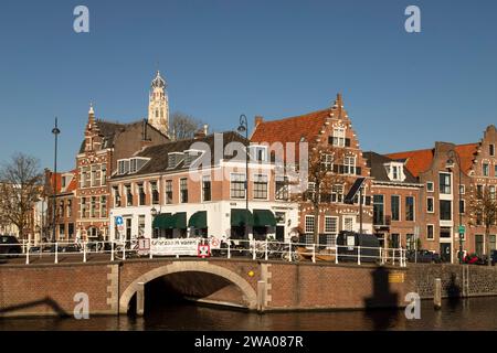 Maisons de canal le long de la rivière Spaarne avec la tour du Bakenesserkerk en arrière-plan dans la ville hollandaise Haarlem. Banque D'Images